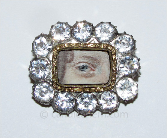 A lady’s blue eye painted in miniature on ivory, set in gold and surrounded by white sapphires. ¾” x ⅝” Late 18th century. 